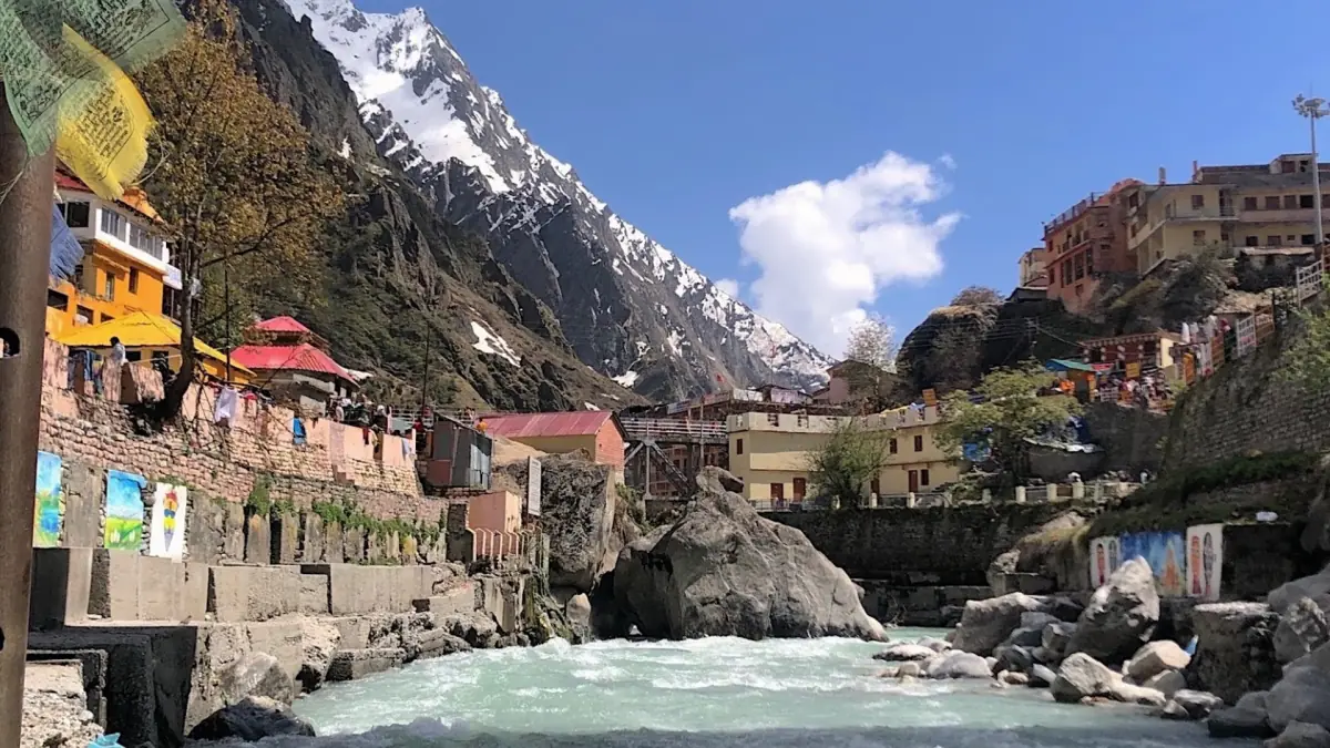Riverside buildings and ghat steps on the Alaknanda below snowy peaks