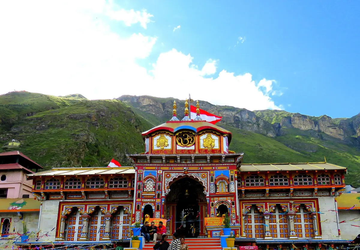 Colorful facade of Badrinath Temple below a green Himalayan hillside