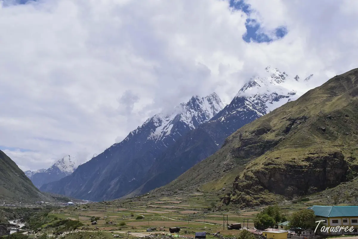 Wide valley near Mana with grazing land and snowy peaks in the distance