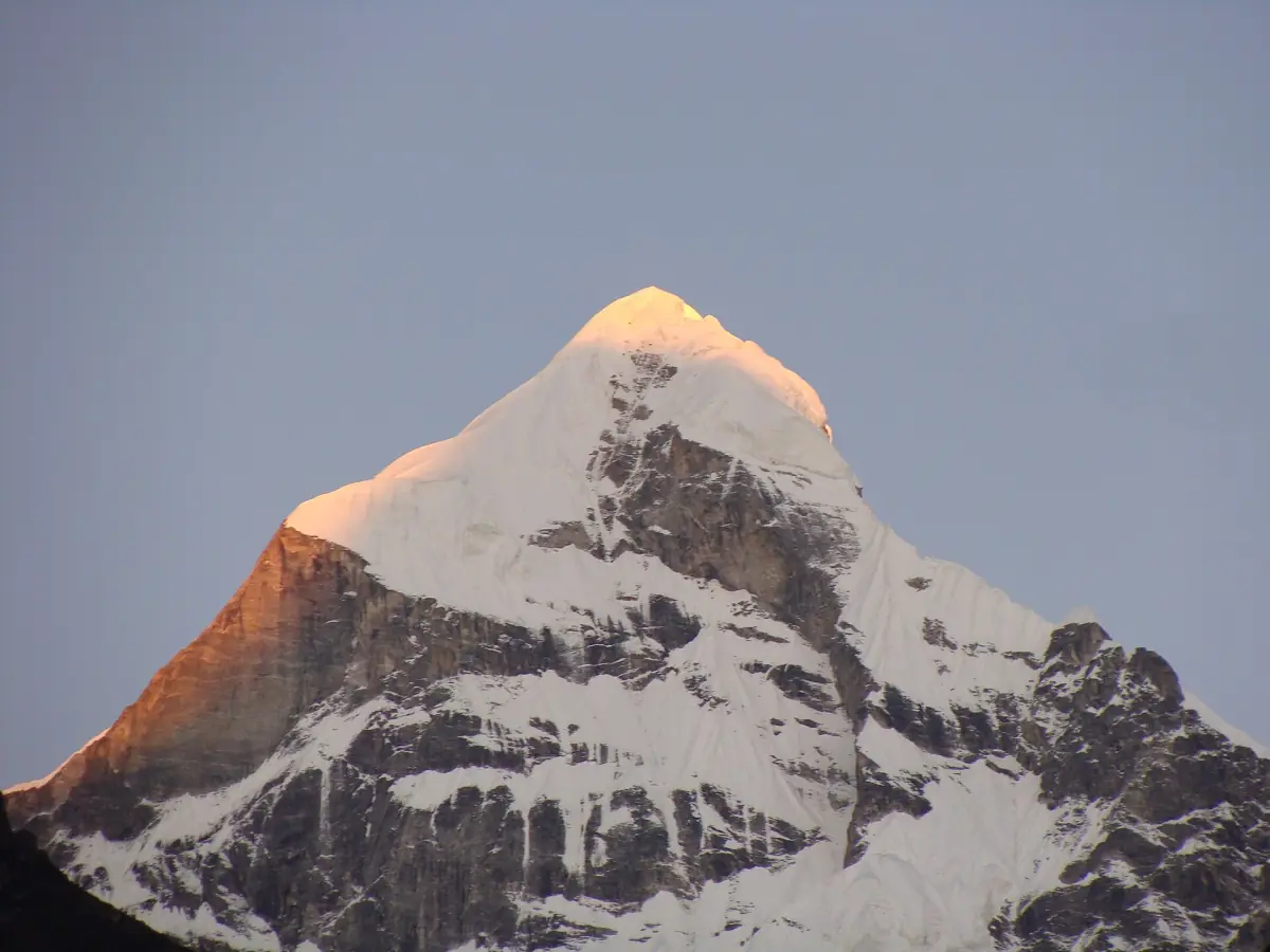 Neelkanth peak with its summit lit orange in the evening light